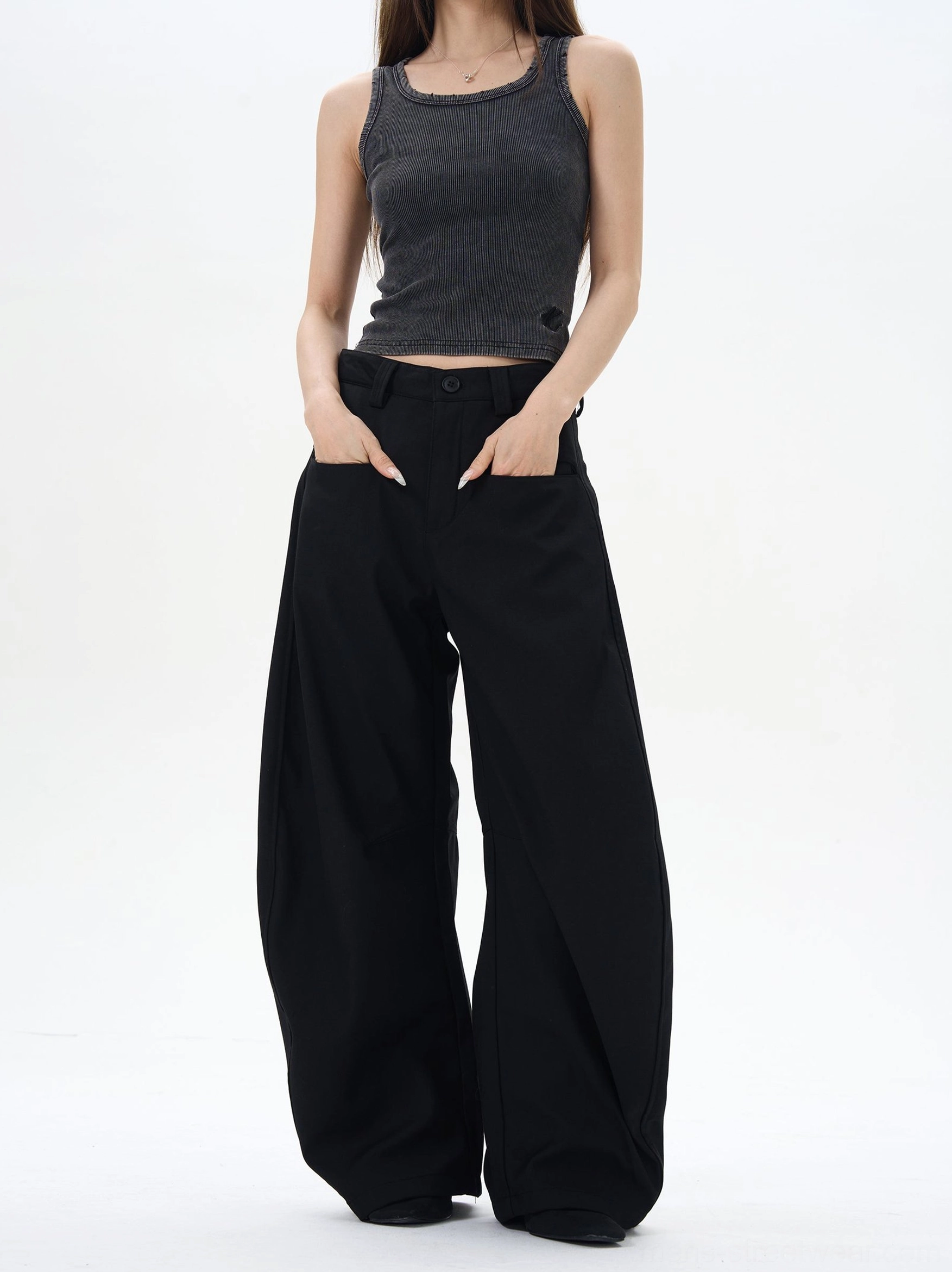 Black high-waisted wide-leg palazzo pants styled with a grey tank top in a minimalist studio, showing the ultra-relaxed Korean streetwear silhouette