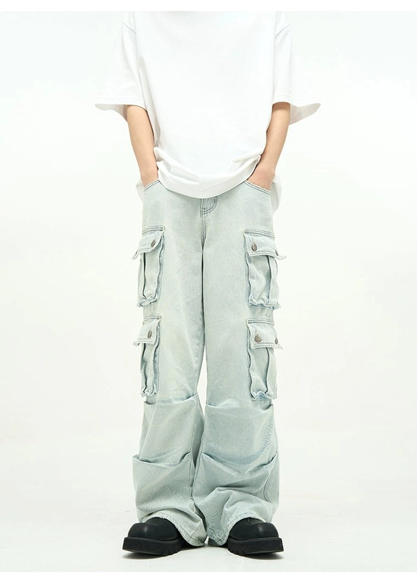 Front three-quarter view of high-waisted light blue cargo jeans with button flap pockets, acid faded denim texture, and loose baggy legs