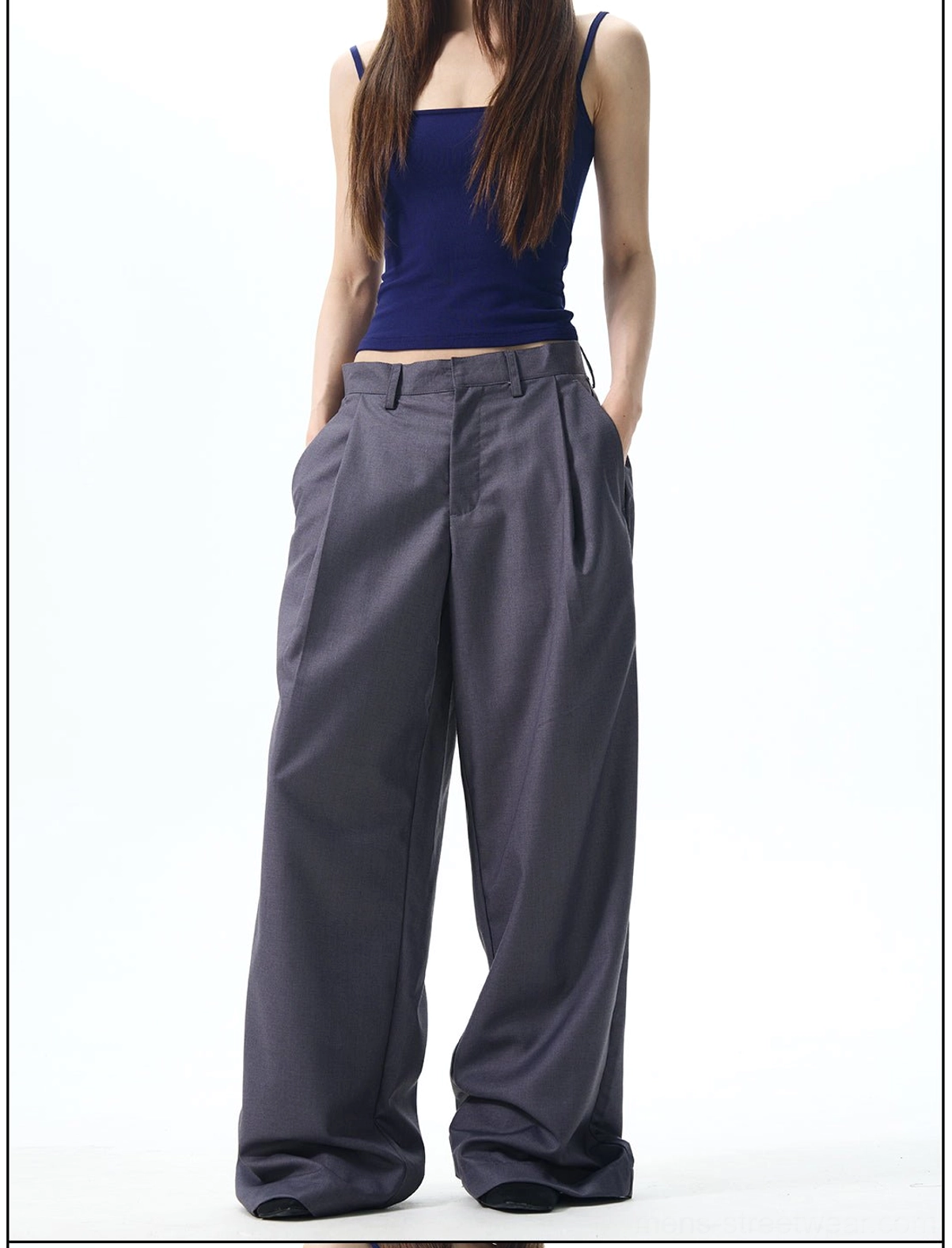 Female model wearing high waisted pleated wide leg trousers with side pockets and flowing Korean streetwear styling