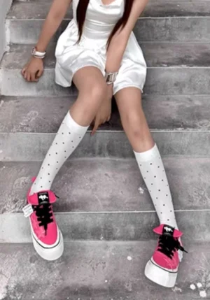 Hot pink canvas star sneakers styled with a white mini dress and polka dot knee high socks in a Korean streetwear outfit
