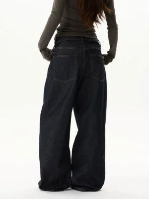 Rear view of dark indigo wide leg denim jeans showing high-rise waist, classic back pockets, contrast stitching, and oversized streetwear fit