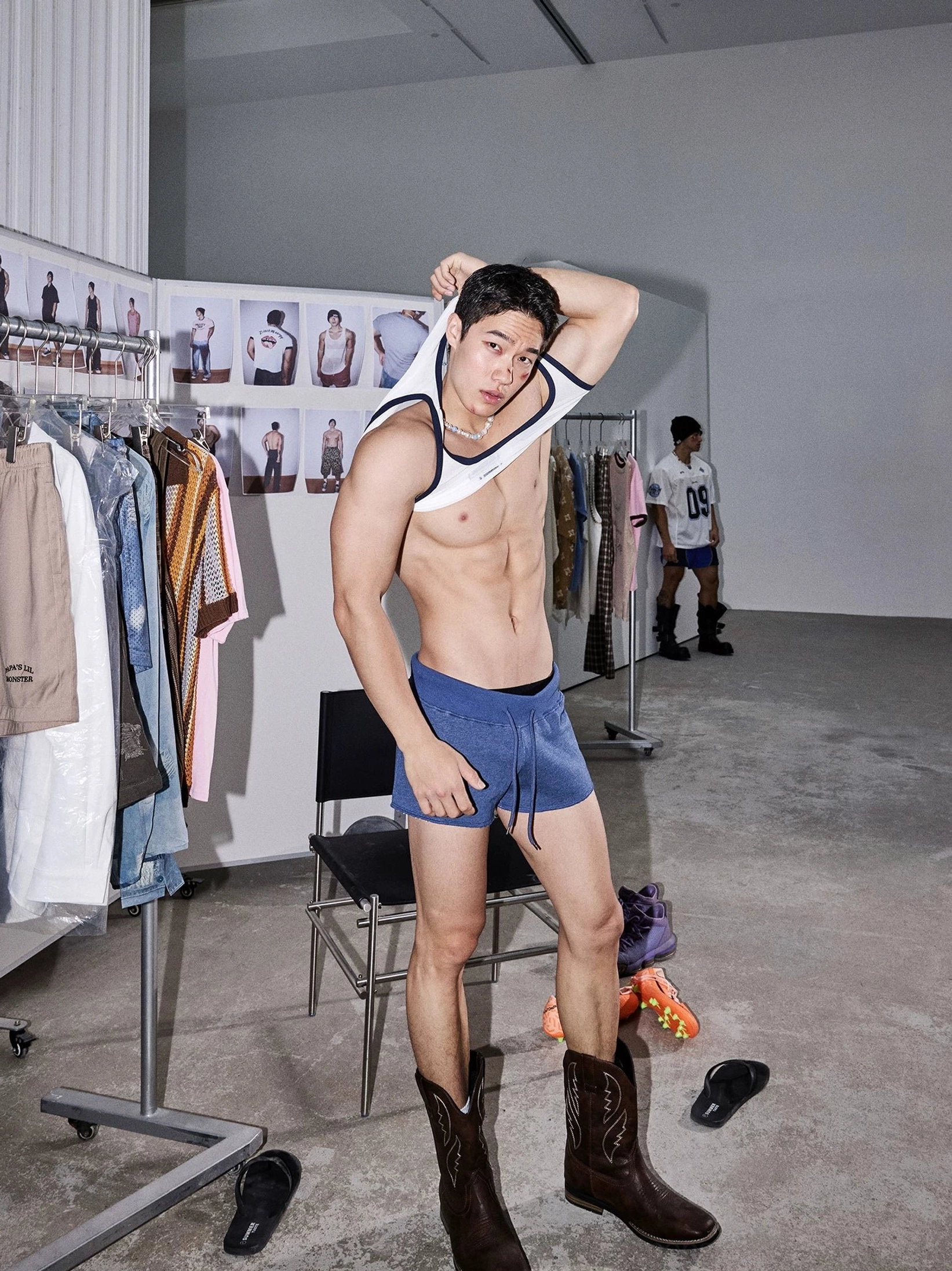 Side three-quarter view of indigo cutoff sweat shorts paired with a white tank top and cowboy boots in a Korean-inspired outfit