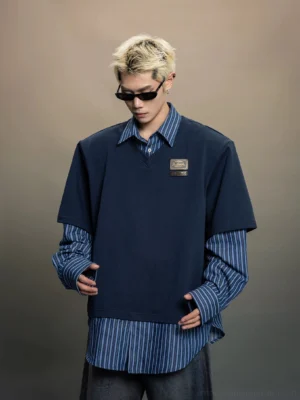 Half body front view of an indigo oversized layered shirt top showing the blue striped inner layer, neat seams, exposed hem, and metal chest detail