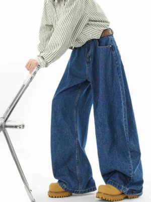 Indigo super balloon wide-leg denim jeans side view styled with striped shirt brown belt and yellow work boots