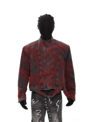 Front full-body view of washed red and charcoal ruched moto denim jacket with stand collar, metal zipper, adjustable waist strap, and distressed flared denim styling