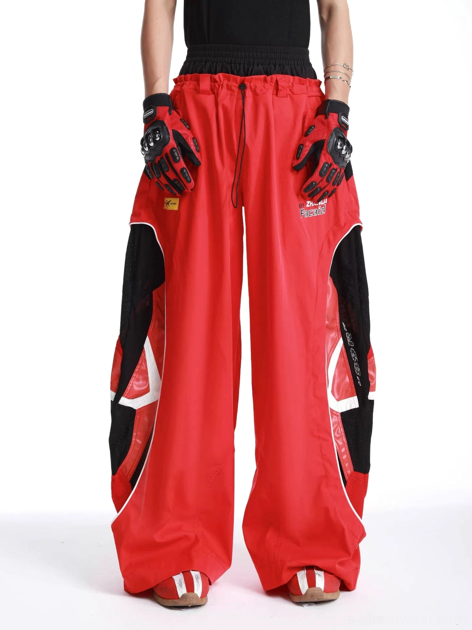 Red inferno vector ultra wide-leg track pants front view worn with black streetwear top and racing gloves