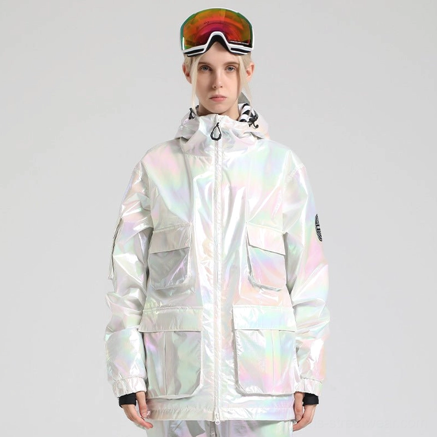 Iridescent white ski storm jacket worn with ski goggles, multiple cargo pockets, attached hood, ribbed cuffs, and embossed sleeve detail