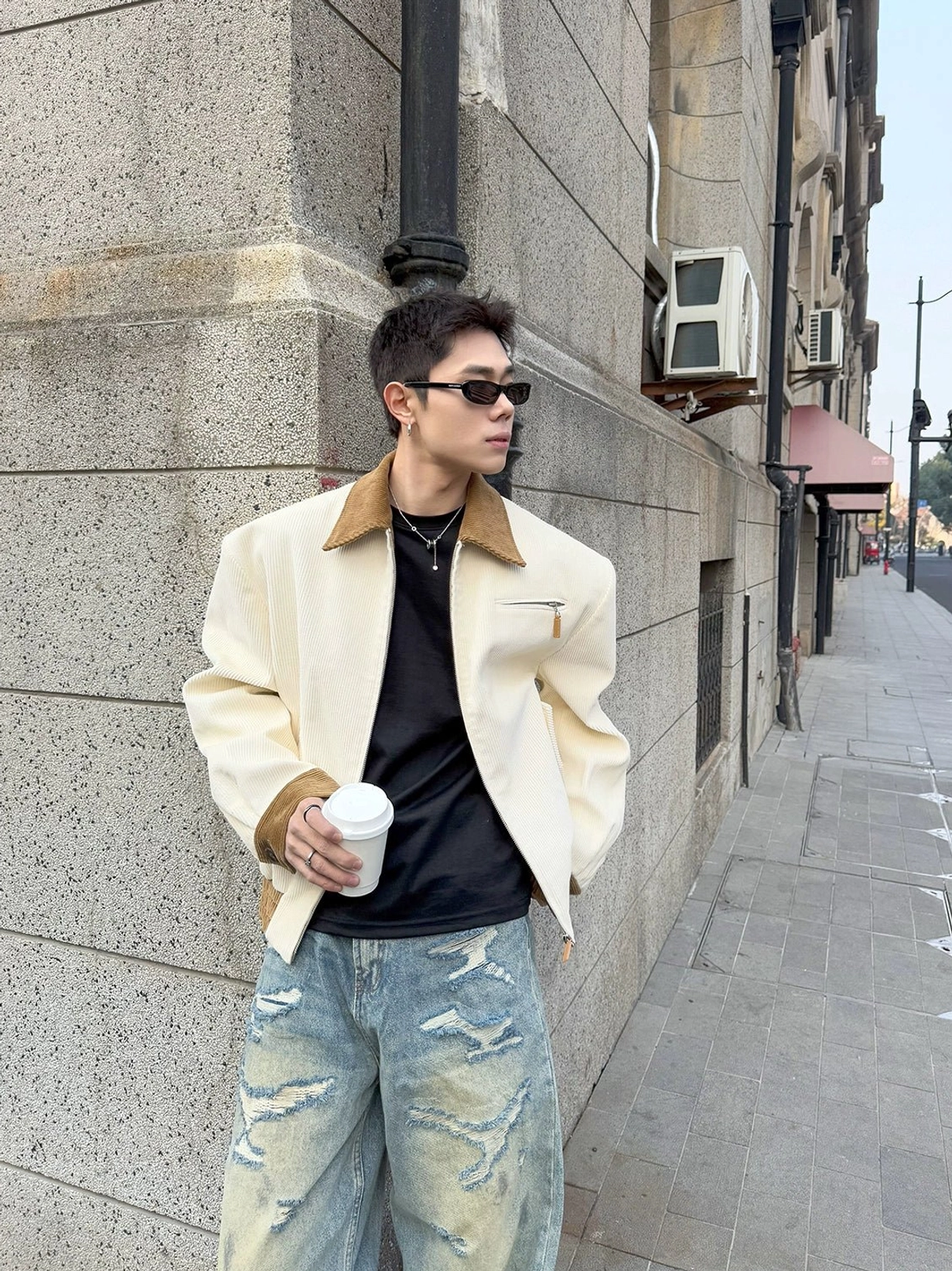Front view of ivory contrast corduroy collar urban jacket styled with black tee ripped jeans and coffee cup