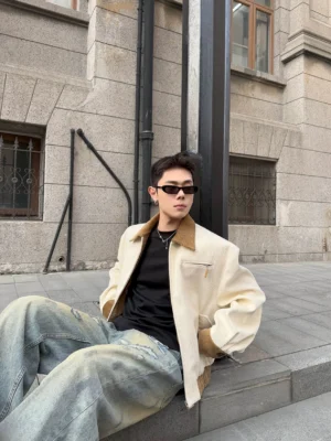 Ivory contrast corduroy collar jacket in apricot color worn by male model sitting on vintage stone steps