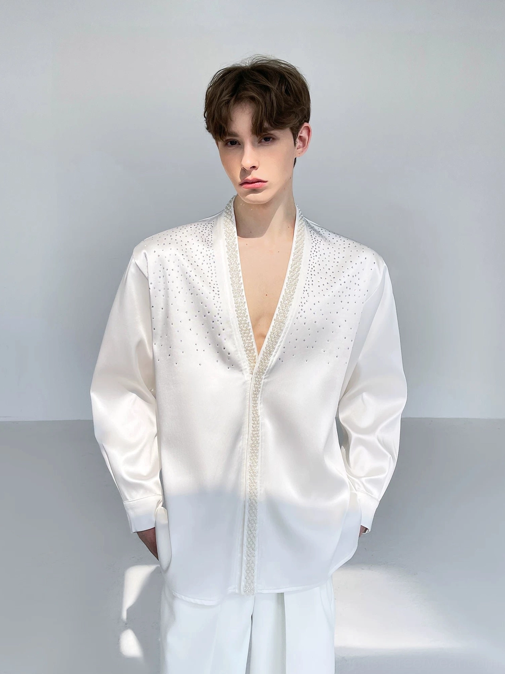 Men's ivory satin streetwear shirt shown in a full front view with a deep V-neck, relaxed oversized fit, loose long sleeves, and smooth formal sheen
