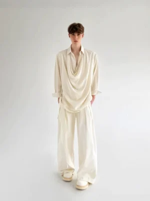 Men's ivory draped cowl neck shirt styled with wide-leg pants in a minimalist Korean streetwear studio outfit