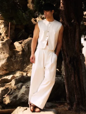 Ivory minimalist button vest styled with wide leg trousers in an outdoor Korean streetwear look