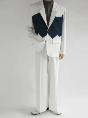 Full-body view of a relaxed ivory Western-inspired suit with dark navy contrast pocket panels and wide-leg tailored trousers