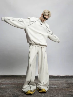 Ivory oversized sweatshirt and wide-leg contrast stitch sweatpants outfit styled with casual sneakers in a contemporary Korean streetwear look