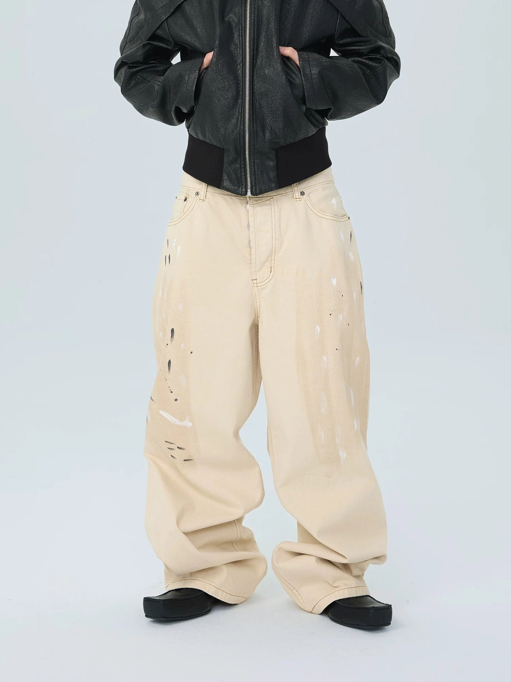 Distressed white wide leg stack jeans front view showing abstract brushstroke print and relaxed balloon silhouette