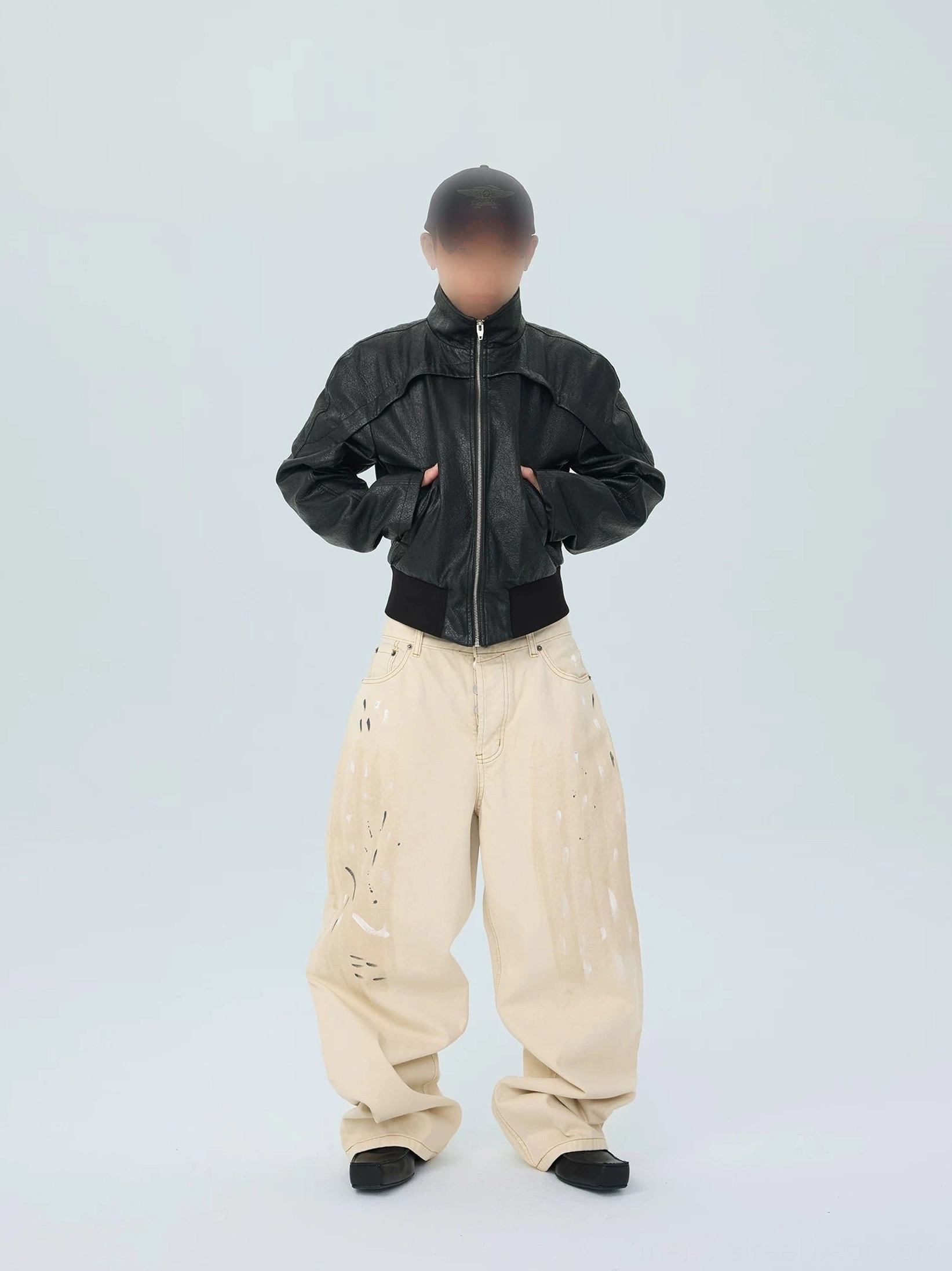 Front view of ivory paintstroke balloon jeans styled with black cropped leather jacket and black loafers