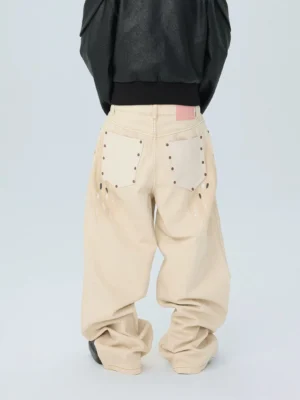 Back view of distressed white paint splatter wide leg jeans with five pocket denim construction and pink waist patch