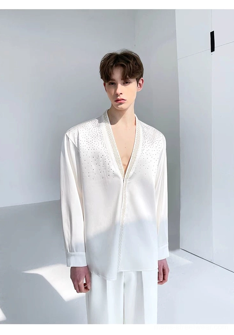 Three-quarter full-body view of a relaxed ivory satin rhinestone shirt with loose sleeves, pearl front trim, and white trousers