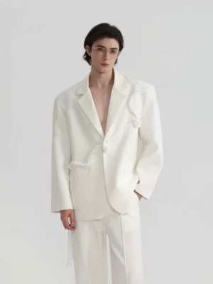 Front full-body view of ivory rose sculpted oversized blazer styled with wide-leg trousers in avant-garde mens streetwear look