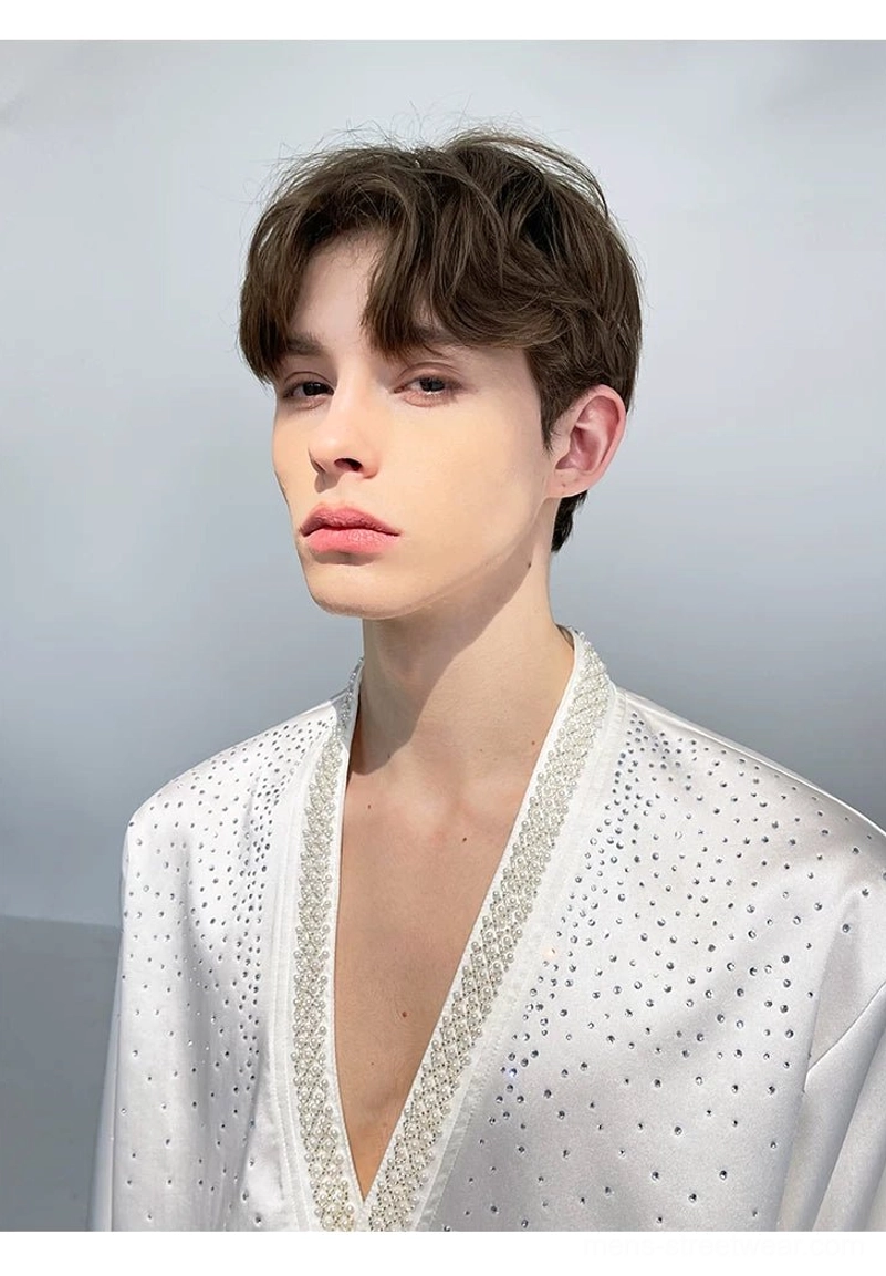 Head and shoulders close-up showing the ivory satin shirt's pearl-trimmed deep V-neckline and sparkling rhinestone embellishment