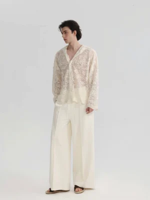Side profile of a relaxed ivory sheer lace hooded shirt styled with wide-leg trousers and slide sandals for modern Seoul street fashion