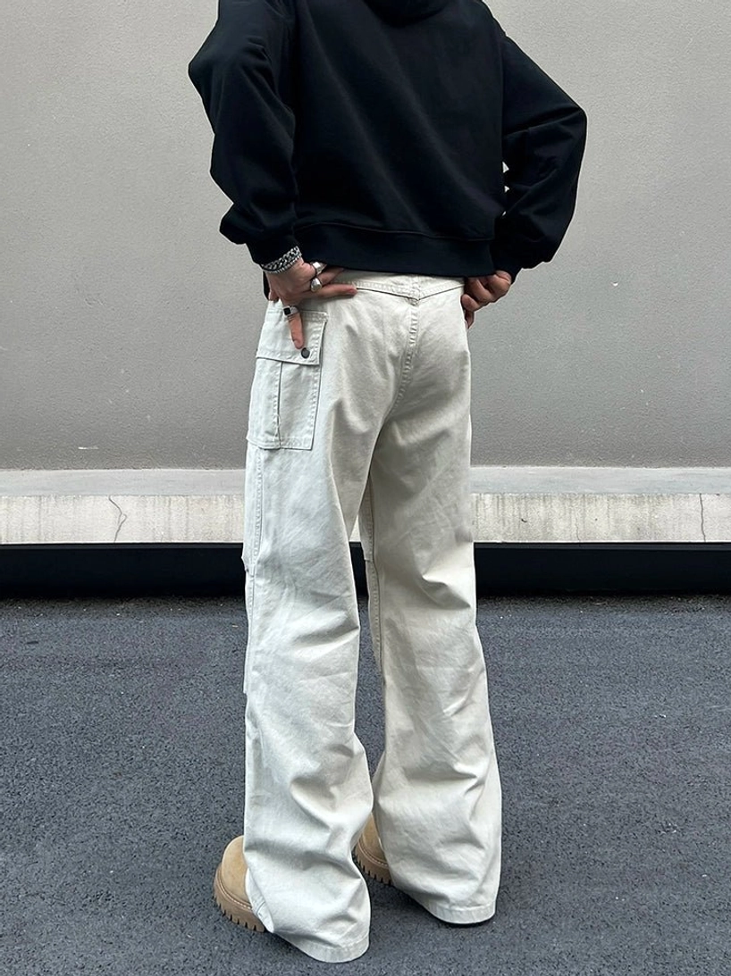 Rear view of ivory wide leg cargo pants showing back utility pockets relaxed workwear silhouette and washed canvas finish