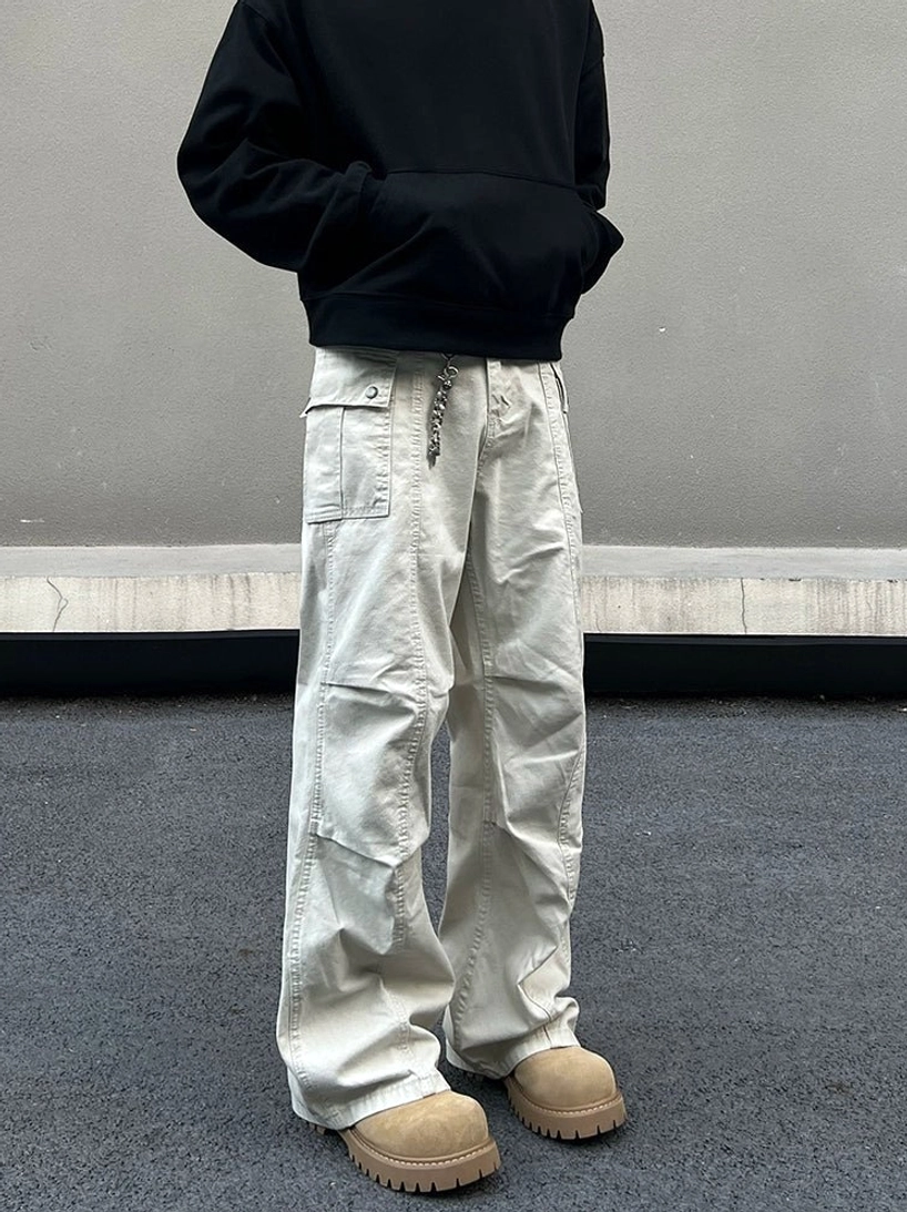 Ivory washed canvas wide leg utility cargo pants with flap pockets and metal waist chain styled with black hoodie and work boots