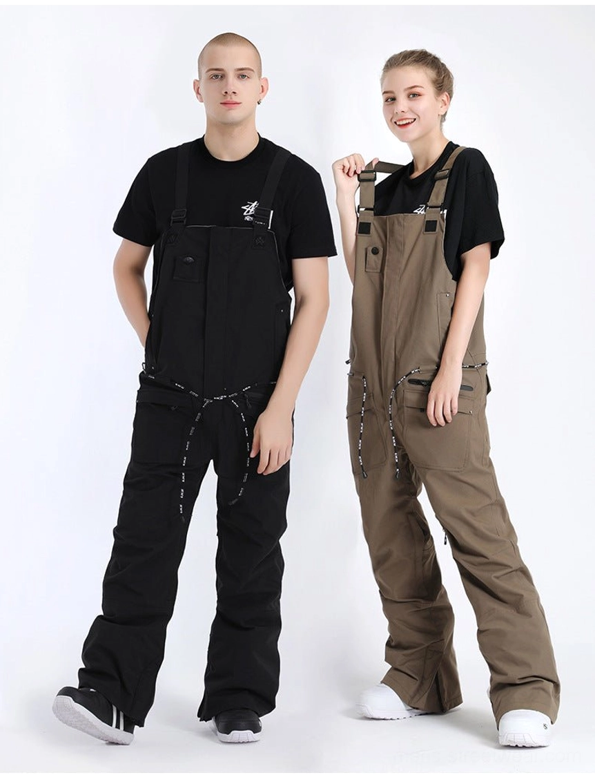Side view of khaki and black unisex bib snow pants showing the loose relaxed fit, high-rise bib construction, adjustable straps, and cargo utility pockets