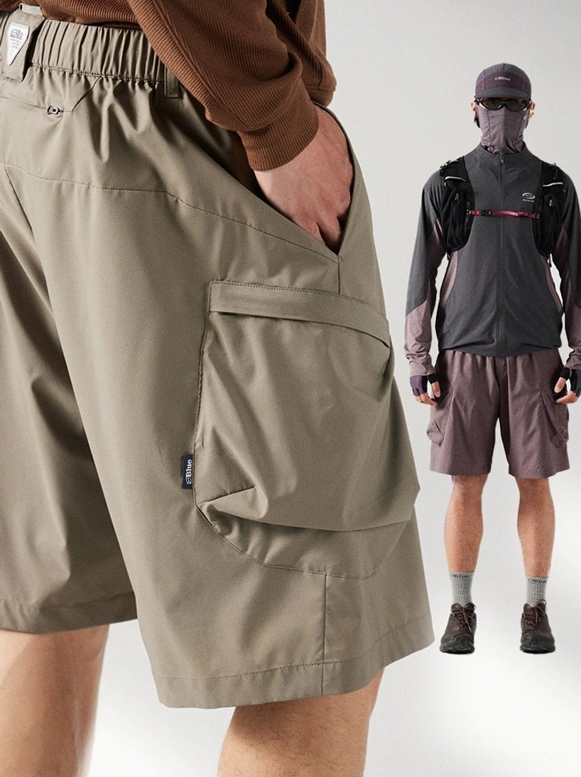 Close-up of khaki breathable cargo shorts showing the elastic waistband, flap cargo pocket, utility construction, and detailed streetwear finish