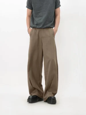 Khaki fluid wide-leg trousers shown from the front with pleated details, long draped legs, side pockets, and chunky black platform loafers