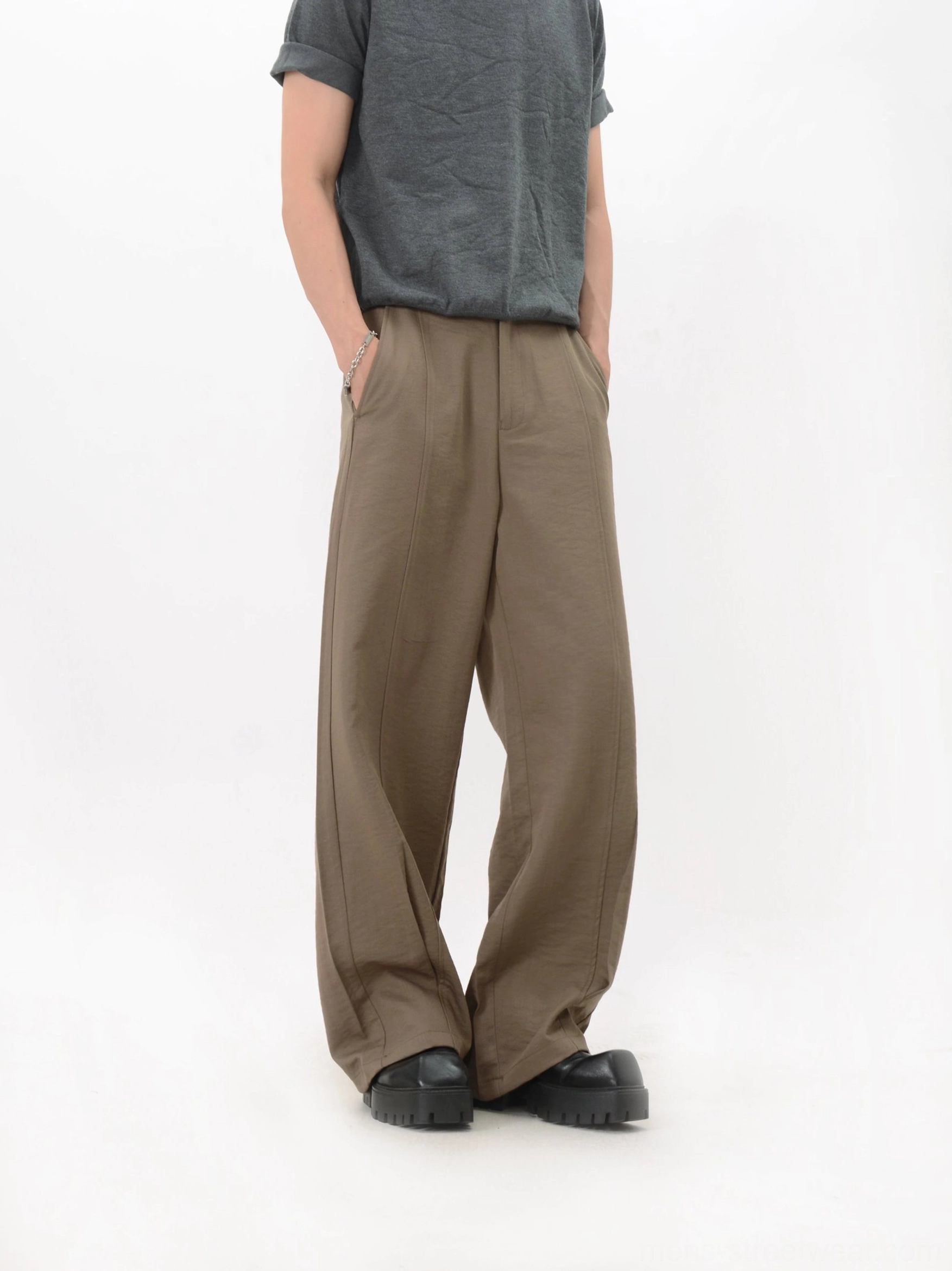 Khaki fluid trousers shown from a three-quarter angle with natural fabric folds, relaxed wide legs, and practical side pocket