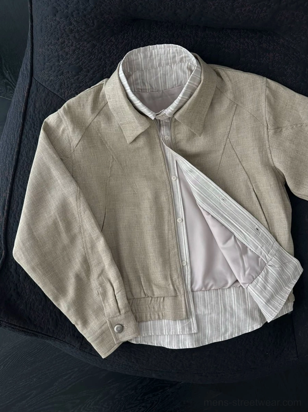 Partially unzipped khaki linen blend layered collar jacket showing light inner lining two-way zipper and striped hem