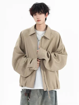 Khaki oversized zip-up streetwear jacket shown from the front with relaxed sleeves, dropped shoulders, clean collar, white T-shirt, and faded blue jeans
