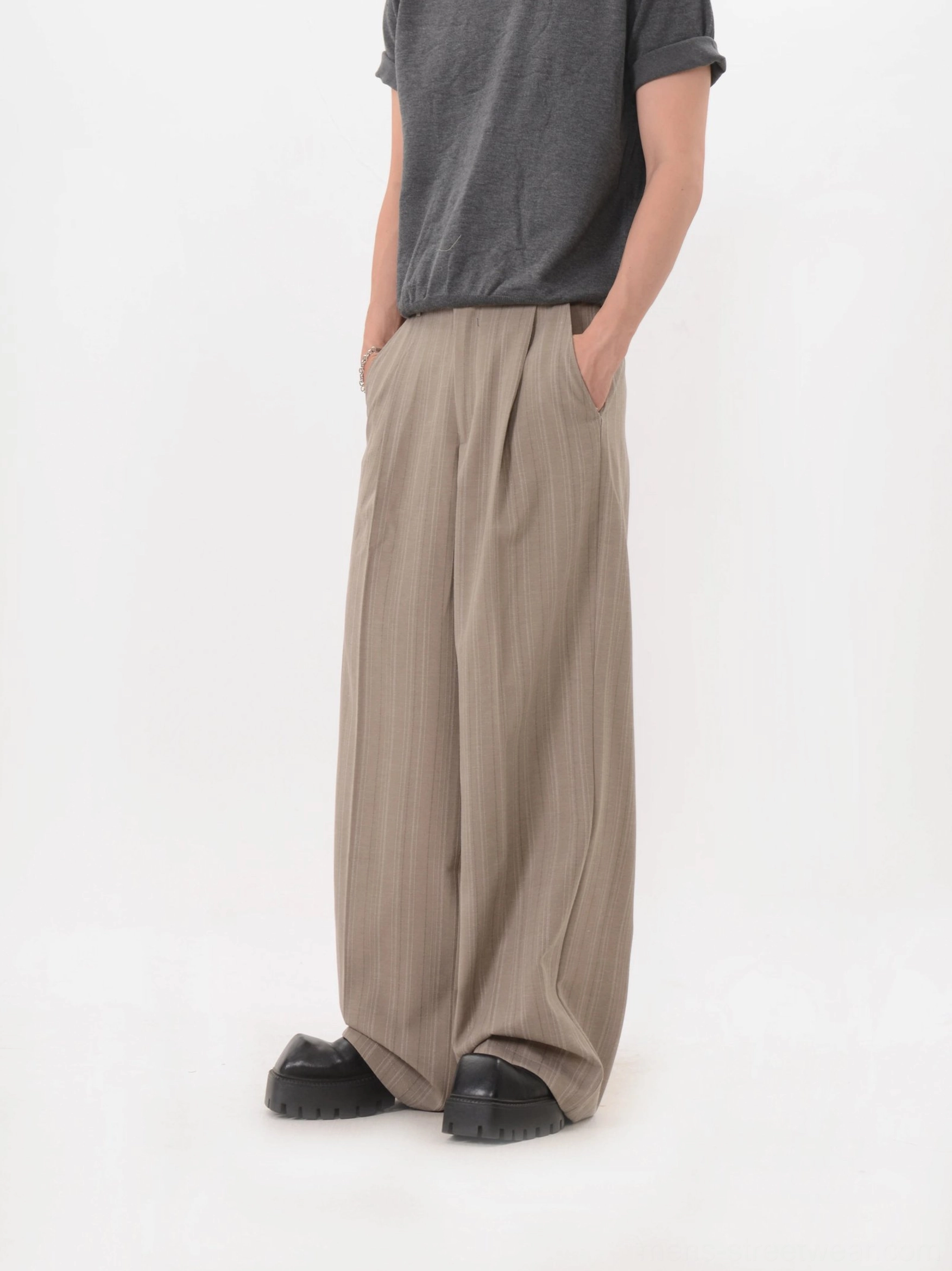 Side rear view of relaxed khaki wide-leg trousers with a long draped streetwear silhouette