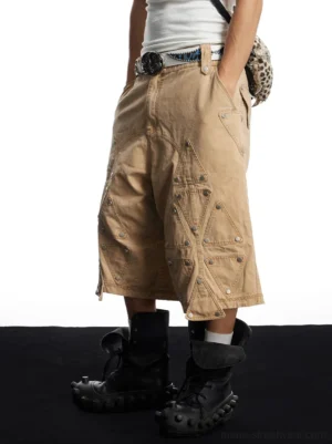 Rear low-angle view of oversized khaki cotton utility long shorts showing back patch pockets, washed fabric, and wide knee-length fit