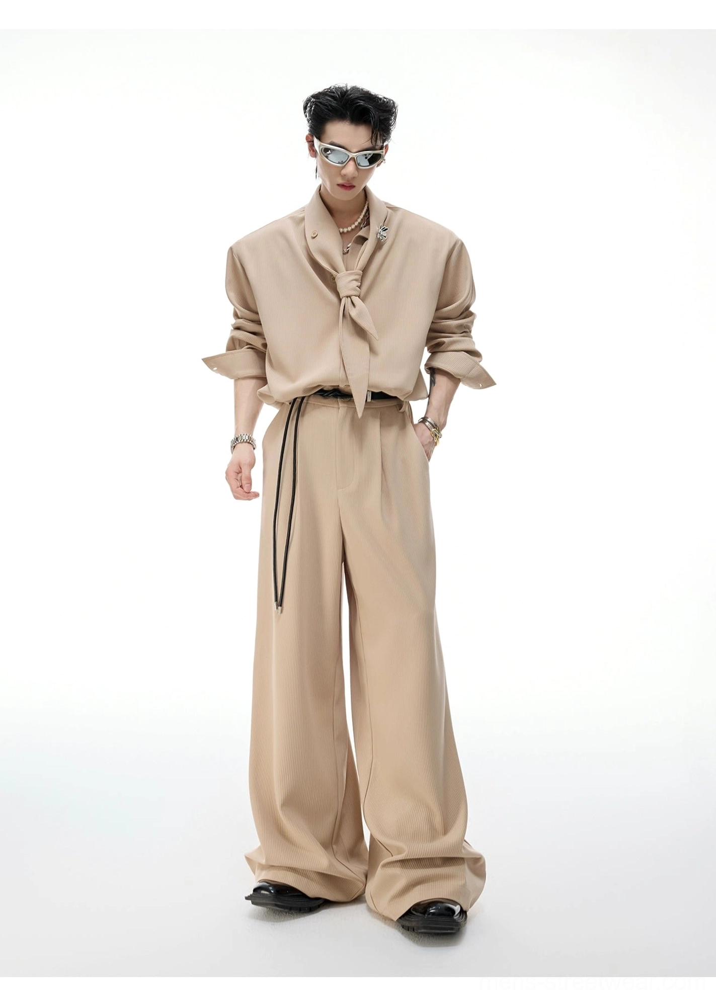 Khaki scarf collar wide-leg suit set on a male model with rolled sleeves, tied stand collar, drawstring waistband, and flowing full-length trousers