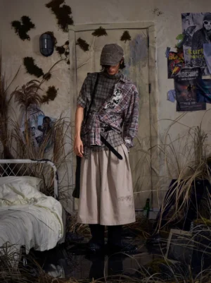 Khaki sunburst embroidered cropped wide-leg trousers styled with plaid shirt, newsboy cap and crossbody bag in a vintage streetwear outfit