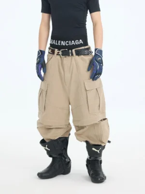 Khaki wide-leg convertible cargo pants styled in an oversized urban streetwear outfit with detachable zip-off leg sections and utility pocket details