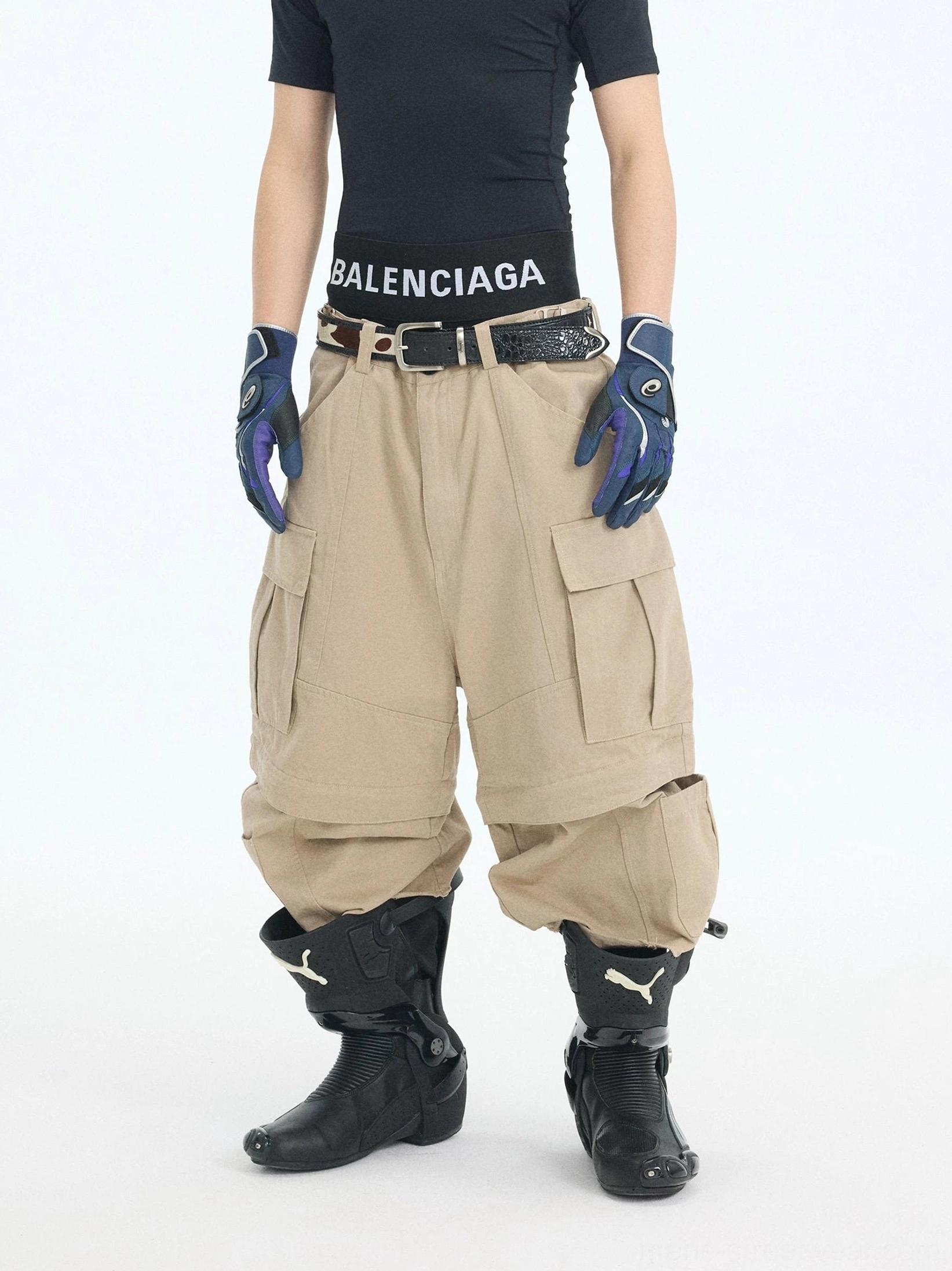 Khaki wide-leg convertible cargo pants styled in an oversized urban streetwear outfit with detachable zip-off leg sections and utility pocket details