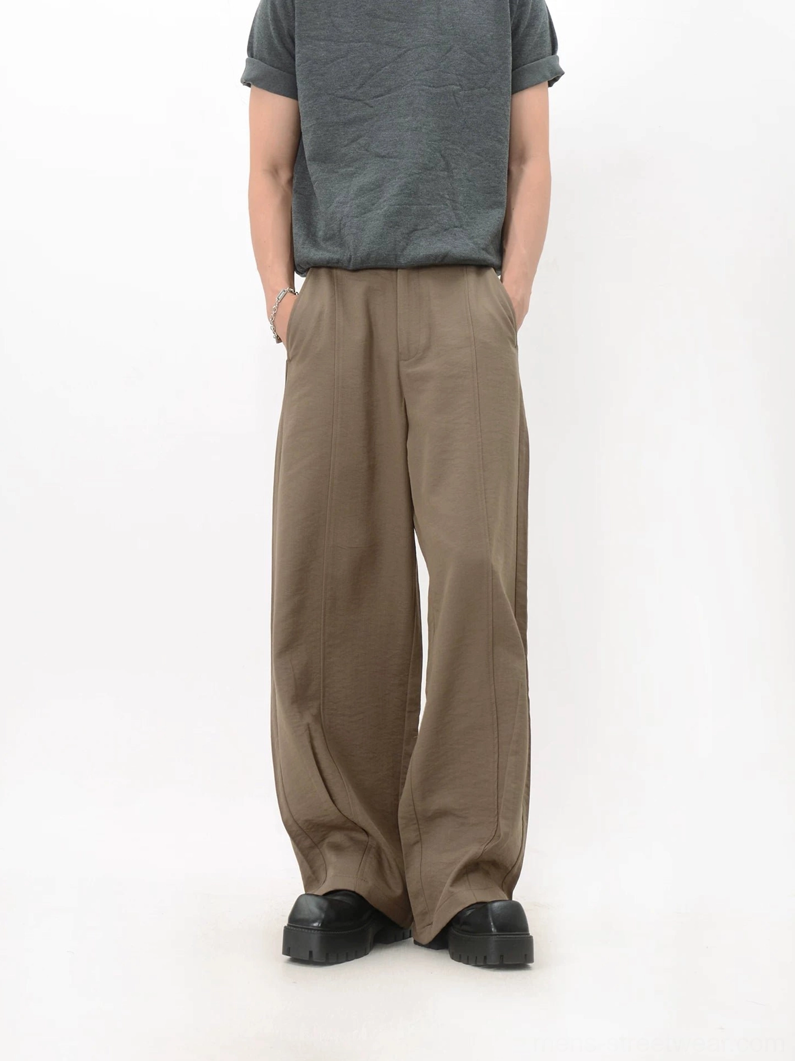Front view of khaki wide-leg trousers showing the relaxed loose silhouette, smooth flowing fabric, and full-length streetwear fit