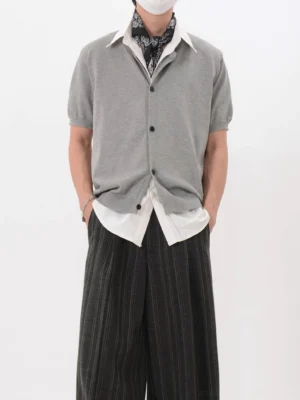 Gray short sleeve button-front knit cardigan in a Korean streetwear layered outfit with wide-leg striped trousers