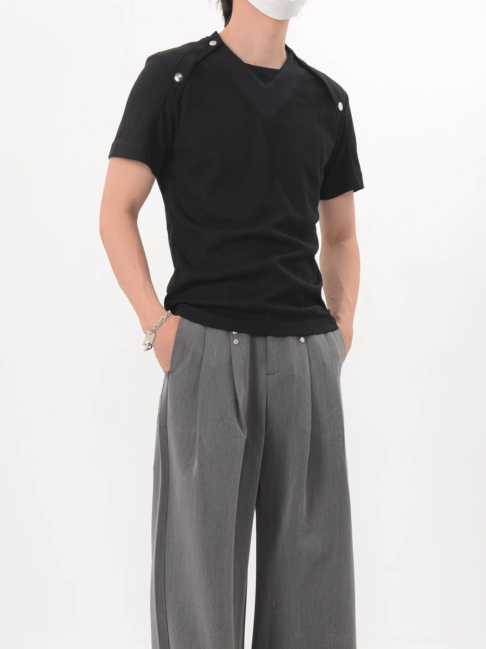 Black Korean streetwear shoulder snap fitted knit tee shown from the left front with V-shaped chest panel and metal shoulder hardware