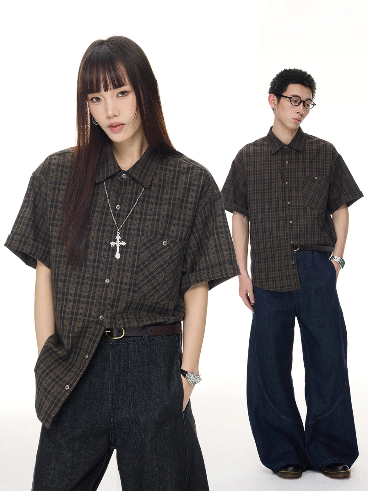 Korean streetwear styling with a relaxed coffee plaid button shirt, dark denim trousers, cross necklaces, and partial tuck