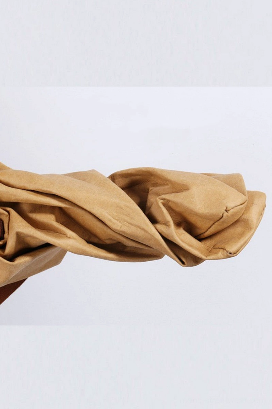 Close-up of camel khaki crinkled cotton fabric with soft washed faux kraft paper texture