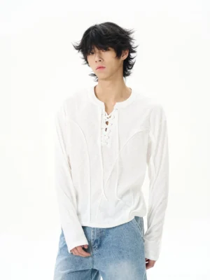 White lace-up Henley long sleeve streetwear shirt shown from the front with a relaxed fit, textured fabric, and blue jeans