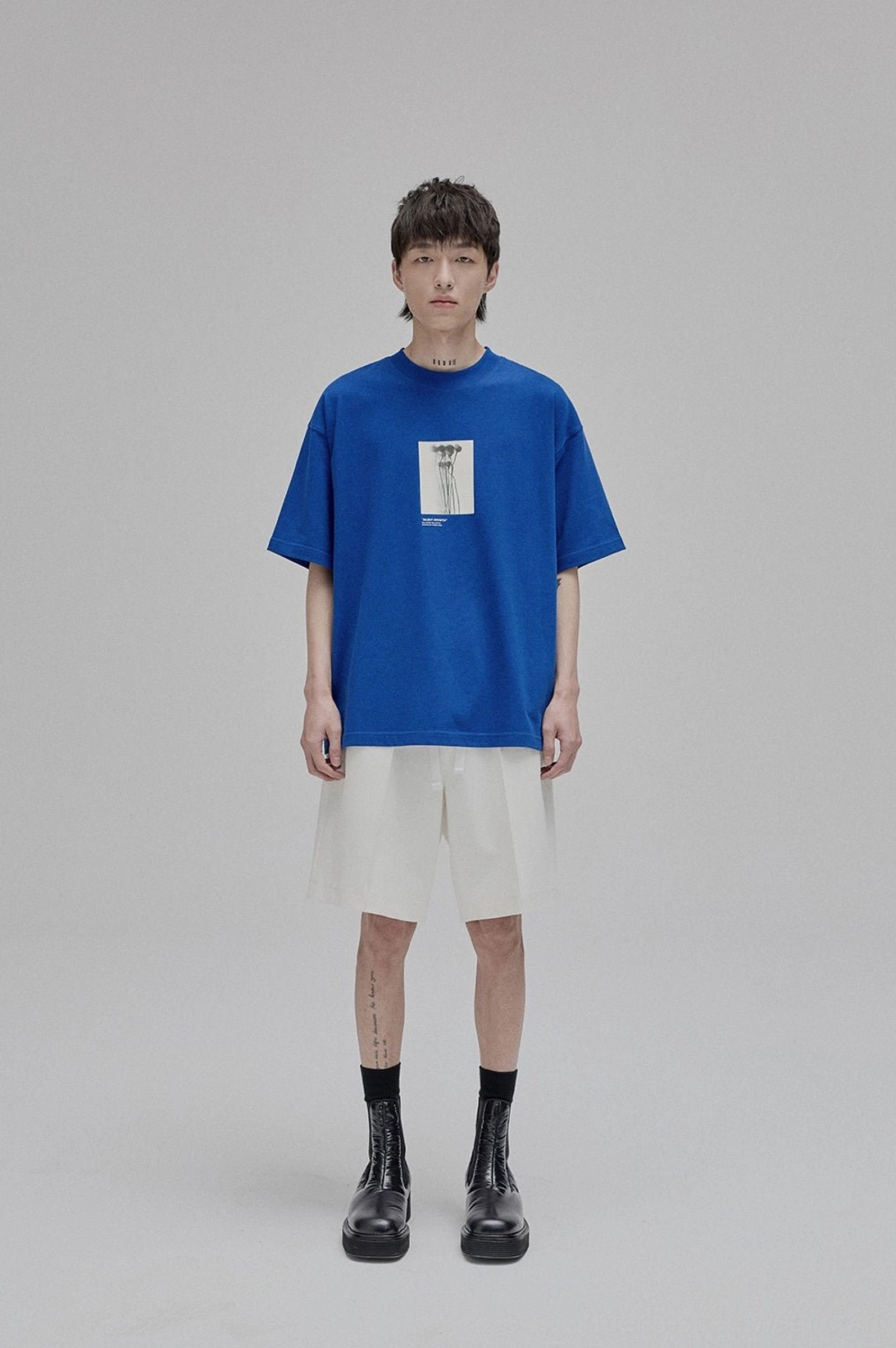 Full body front view male model lace-up straight leg shorts with printed chest tee relaxed silhouette minimalist streetwear