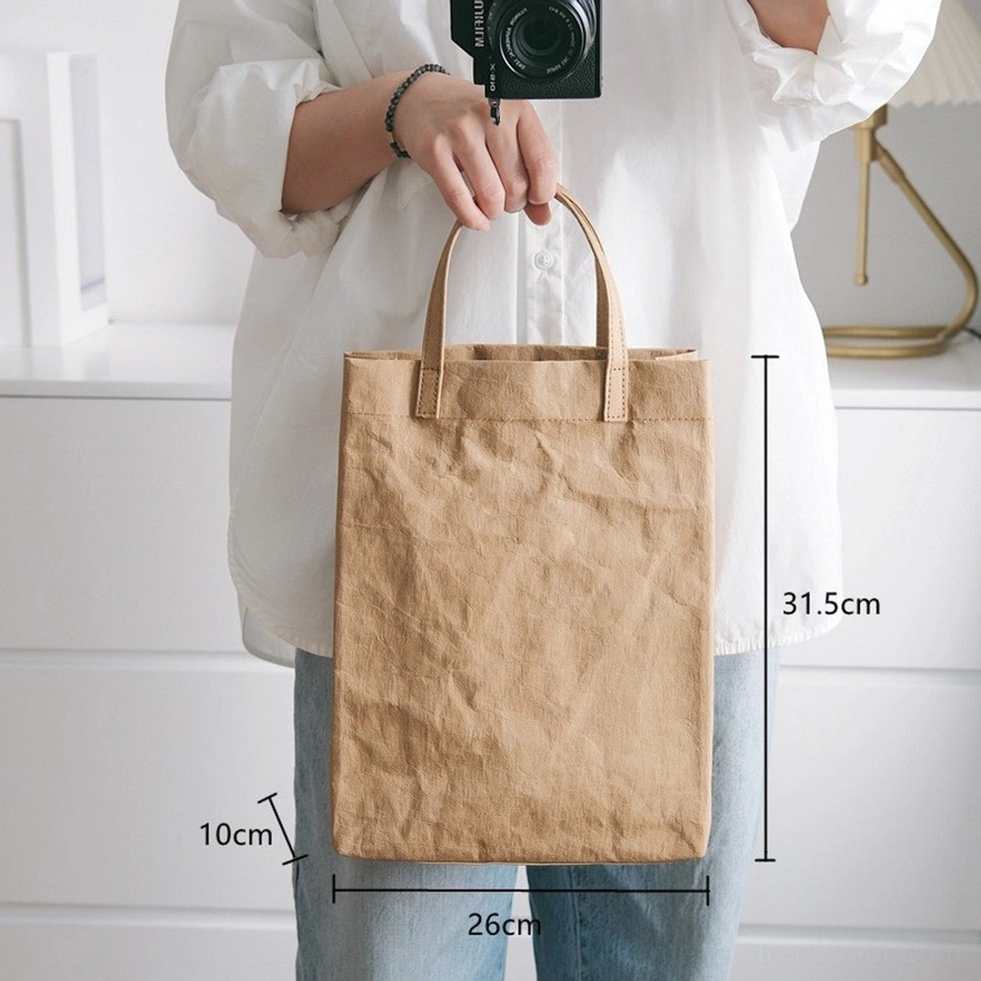 Large khaki faux kraft paper cotton tote bag worn with casual Japanese Korean streetwear outfit showing dimensions