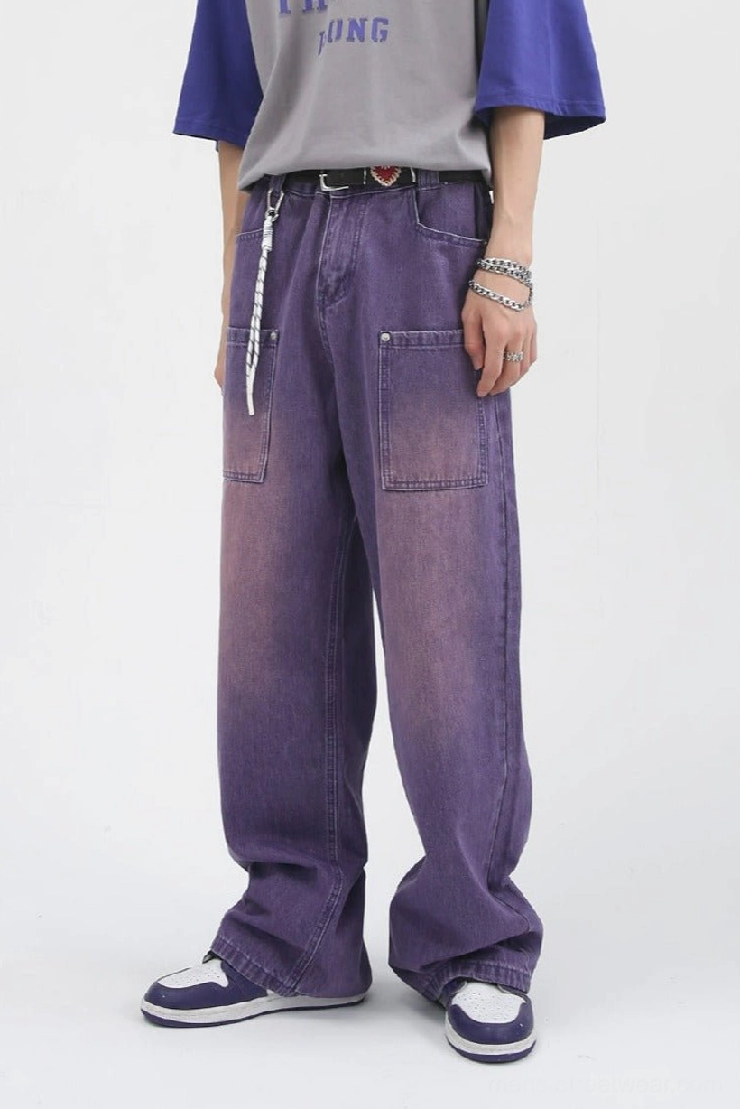 Front low-angle view of lavender washed wide-leg carpenter jeans with oversized utility patch pockets and relaxed streetwear fit