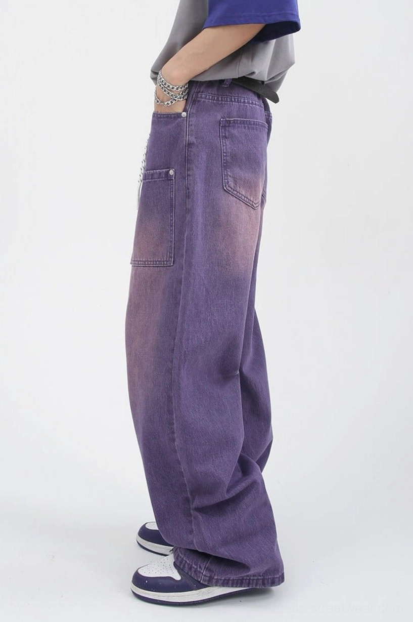 Side view of faded purple wide-leg carpenter jeans showing loose full-length silhouette and side denim construction