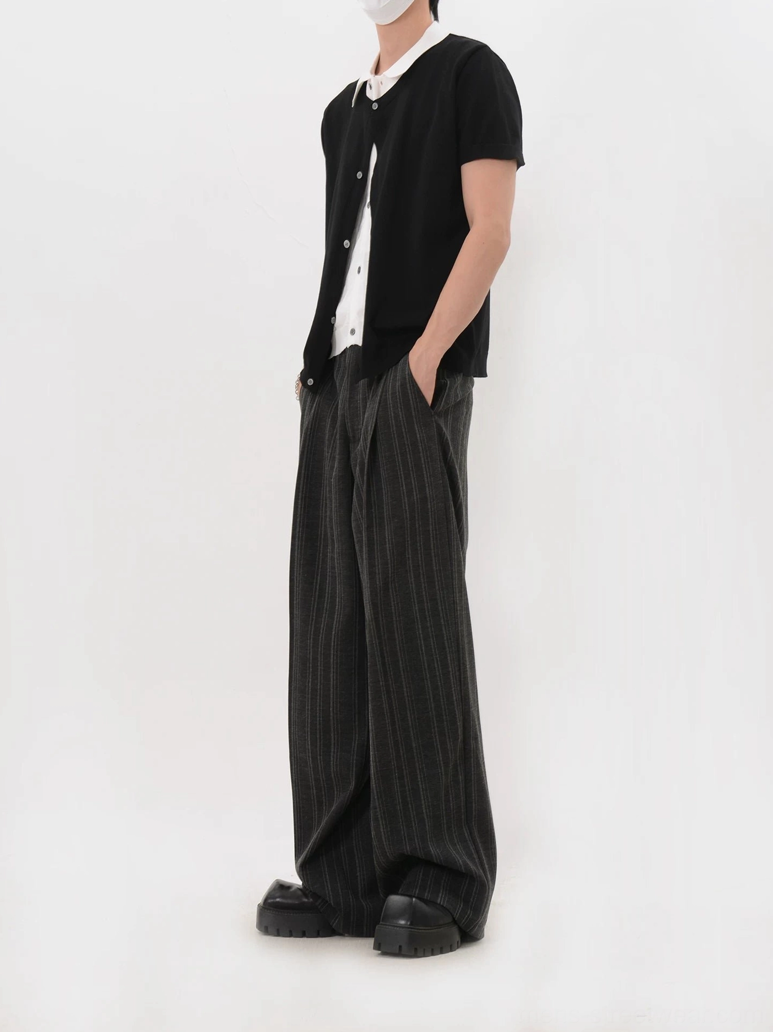 Side view of black layered collar knit cardigan shirt showing the cropped hip-length silhouette and rolled short sleeves